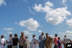 Relatives of Egyptians whose Europe-bound boat capsized off Egypt’s Mediterranean coast watch departing boats that are participating in a search operation, in Rosetta, Egypt, Sept. 22, 2016.