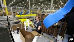 In this Feb. 13, 2015 file photo, a worker places an item in a box for shipment,at a Amazon.com fulfillment center in DuPont, Washington.