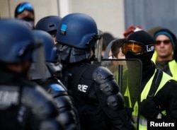 Protesters wearing yellow vests face riot police during a demonstration of the "yellow vest" movement in Angers, France, Jan. 19, 2019.