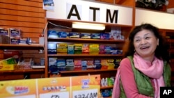 Owner Young Soolee basks in the attention at her small Alliance Center office bulding newsstand on Dec. 18, 2013, in Atlanta, after lottery officials said one of two winning Mega Millions lottery tickets were purchased from her store.