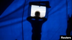 FILE - A Kurdish refugee boy from Kobani tries to look into his new school at a refugee camp in the border town of Suruc, Sanliurfa province, Turkey, Nov. 2, 2014.