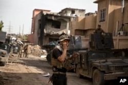FILE - An Iraqi special forces soldier speaks on the radio as troops move from the Yarmouk neighborhood to take another district from Islamic State militant control in Mosul, Iraq, April 12, 2017.