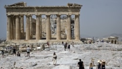 FILE - Tourists visit the Ancient Acropolis archeological site in Athens on July 1, 2021.