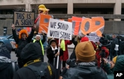 People gather to show support and protest former campaign adviser for President Donald Trump, Roger Stone, after he departed federal court in Washington, Jan. 29, 2019.