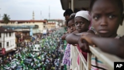 Girls watch a rally for Sierra Leone opposition presidential candidate Julius Maada Bio from their terrace in downtown Freetown, November 15, 2012.