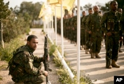 U.S.-backed Syrian Democratic Forces (SDF) stand in formation at a ceremony to mark their defeat of Islamic State militants in Baghuz, at al-Omar Oil Field base, Syria, March 23, 2019.