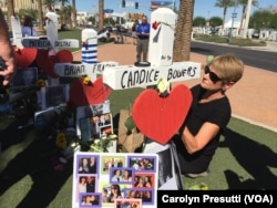 Tina Lund embellishes the cross of her friend Brian Fraser, a father of four from California. She cared for the marker like a victim’s mother, gently wrapping blue ribbon around the cross and hanging a collage of photos.