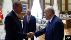 Turkey's President Recep Tayyip Erdogan, left, greets Devlet Bahceli before a meeting in Ankara, Turkey, July 25, 2016. Erdogan met Monday with leaders of the main opposition parties, Republican People's Party leader Kemal Kilicdaroglu, National Movement Party leader Devlet Bahceli and Turkish Prime Minister Binali Yildirim.