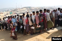 Rohingya refugees stand in a queue to collect aid supplies in Kutupalong refugee camp in Cox's Bazar, Bangladesh, Jan. 21, 2018.