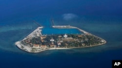 FILE - The Vietnamese-claimed Southwest Cay island in the Spratly island group is seen from a Philippine Air Force C-130 transport plane during the visit to the Philippine-claimed Thitu Island by Defense Secretary Delfin Lorenzana.