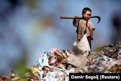 An illegal immigrant boy from Myanmar collects plastic at a rubbish dump near Mae Sot December 22, 2009.