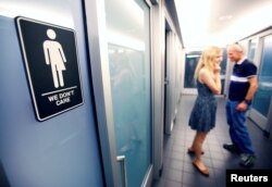 FILE - A sign protesting a recent North Carolina law restricting transgender bathroom access adorns the bathroom stalls at the 21C Museum Hotel in Durham, North Carolina, May 3, 2016.