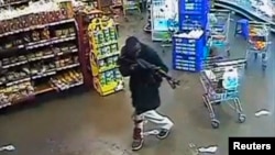 FILE - A gunman aims his rifle inside a store during an attack on the Westgate shopping mall in this still frame taken from video footage by security cameras inside the mall in Nairobi and released to Reuters on Oct. 17, 2013.