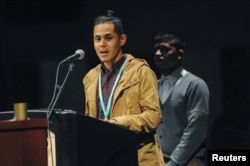 Raul and Jorge, representing Deferred Action for Childhood Arrivals (DACA) students, say a prayer during a Spanish-language Mass focusing on immigrants, exiles and refugees with their children during the four-day 2017 Religious Education Congress in Anaheim, Calif., Feb. 25, 2017. Participants in the picture asked that their last names not be used.
