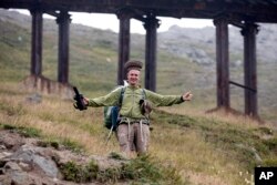 In this Saturday, Aug. 18, 2018, photo, Roger Shepherd, founder of Hike Korea, wears a North Korean hat he found while hiking down Mount Paektu in North Korea.