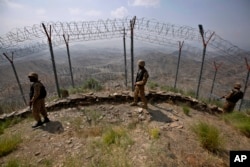 FILE - Pakistan Army troops patrol along the fence on the Pakistan-Afghanistan border at Big Ben hilltop post in Khyber district, Pakistan, Aug. 3, 2021.