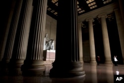 Visitors take their pictures at the Lincoln Memorial in Washington, Jan. 1, 2019, as a partial government shutdown approaches its two-week mark.