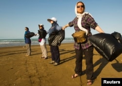 FILE - Nature lovers participate in a trash disposal campaign organized by the Persian Wildlife Heritage Foundation in the Miankaleh area, 250 kilometers (155 miles) northeast of Tehran, Sept. 22, 2011. Kavous Seyed-Emami, managing director of the foundation killed himself an Iranian prison, something friends and family dispute.
