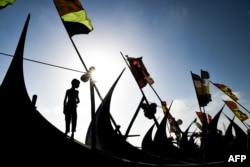 FILE - A Rohingya refugee boy looks on as he stands on a fishing boat at Shamlapur camp in Teknaf.
