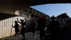 FILE - Indigenous people protest Brazilian President Jair Bolsonaro's proposals to allow mining on Indigenous lands in Brasilia, Brazil, June 16, 2021.