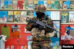 A Belgian soldier stands guard in front of a shop selling Tintin comic books in central Brussels, Belgium, March 24, 2016.