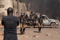 A protester faces security forces during a demonstration in Ouagadougo, Burkina Faso, Nov. 27, 2021.