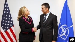 U.S. Secretary of State Hillary Rodham Clinton, left, shakes hands with NATO Secretary-General Anders Fogh Rasmussen at the NATO headquarters in Brussels, December 4, 2012.