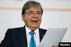 FILE - Colombia's Foreign Affairs Minister Carlos Holmes Trujillo reads a statement after a meeting of the Lima Group in Bogota, Colombia, Feb. 25, 2019.