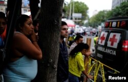 Citizens look at a collapsed building after an earthquake in Mexico City, Mexico, Sept. 25, 2017.