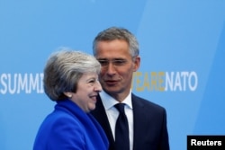 FILE - Britain's Prime Minister Theresa May is welcomed by NATO Secretary-General Jens Stoltenberg at the start of a NATO summit at the Alliance’s headquarters in Brussels, Belgium, July 11, 2018.