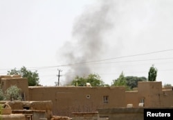 FILE - Smoke rises from a residential area where gun battle is going on between Taliban and Afghan forces in Ghazni province, Afghanistan Aug. 10, 2018.
