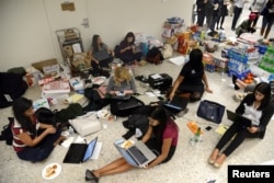 Lawyers and legal assistants network and use social media in the baggage claim area at Dulles International Airport, aiding passengers who have arrived and encounter problems because of Donald Trump's travel ban to the United States, Jan. 29, 2017.