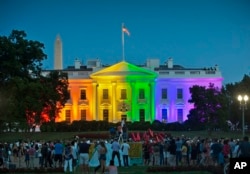 FILE - people gather in Lafayette Park to see the White House illuminated with rainbow colors in commemoration of the Supreme Court's ruling to legalize same-sex marriage in Washington.