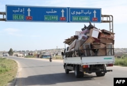 Residents flee with their belongings during reported shelling in rebel-held Idlib province, Syria, May 3, 2019.