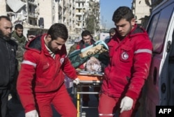 Staff of the Syrian Red Crescent pulls a stretcher with a wounded person during an evacuation operation of rebel fighters and their families from rebel-held neighbourhoods in the embattled city of Aleppo on Dec. 15, 2016.