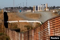 FILE: Prototypes for U.S. President Donald Trump's border wall with Mexico are shown near completion behind the current border fence, in this picture taken from the Mexican side of the border, in Tijuana, Oct. 23, 2017.
