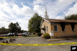 Area residents and church members look on as authorities investigate a fire at Hopewell Baptist Church in Greenville, Mississippi, Nov. 2, 2016. "Vote Trump" was spray-painted on an outside wall of the African American church.