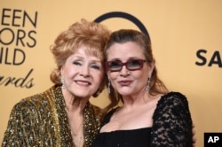 Debbie Reynolds, winner of the Screen Actors Guild lifetime award, left, and Carrie Fisher pose in the press room at the 21st annual Screen Actors Guild Awards at the Shrine Auditorium, Jan. 25, 2015, in Los Angeles.