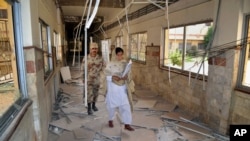 FILE - A Pakistani paramilitary soldier and a nurse walk through a corridor at the Bolan Medical complex damaged by an attack claimed by the Sunni militant group Lashkar-e-Jhangvi, in Quetta, Pakistan, June 16, 2013.