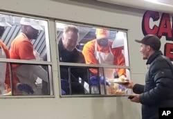 Former California Gov. Arnold Schwarzenegger serves breakfast to firefighters, Nov. 21, 2018, in Chico, Calif. Schwarzenegger has made a surprise visit to firefighters battling a deadly blaze in Northern California, helping serve them breakfast while providing encouragement.