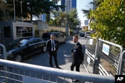 Seen behind barriers blocking the road leading to Saudi Arabia's consulate, security guards stand in Istanbul, Turkey, Oct. 26, 2018.