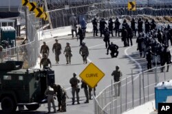 U.S. military personnel and Customs and Border Protection officers gather along the southbound lanes of the San Ysidro port of entry, Nov. 25, 2018, in San Diego, California, at the U.S. border with Mexico.
