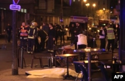 Rescue workers and medics work by victims in a Paris restaurant, Nov. 13, 2015.