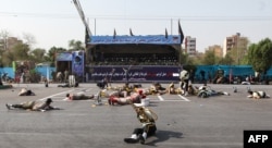 This picture taken on Sept. 22, 2018 in the southwestern Iranian city of Ahvaz shows injured soldiers lying on the ground at the scene of an attack on a military parade that was marking the anniversary of the outbreak of its devastating 1980-1988 war.