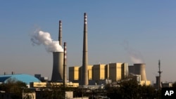 FILE - Smoke billows from a coal-fired power plant in Beijing, China, Nov. 13, 2014. Some countries have been reluctant to drastically cut down coal production and stop coal-based industries because it would result in job losses.