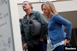 FILE - Lane Walker of Magalia and Genevieve Brink-Capriola of Chico look at a list of people missing in the aftermath of the Camp Fire in Chico, California, Nov. 15, 2018.