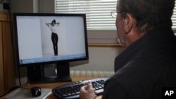 Slovenian retired fashion photographer Stane Jerko looks at a photo of Melanija Knavs, now known as Melania Trump, from their first photo session, in Ljubljana, Slovenia, in this photo taken from AP video Feb. 11, 2016.