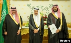 FILE - (L-R) Saudi Crown Prince Mohammed bin Nayef, Saudi King Salman, and Saudi Arabia's Deputy Crown Prince Mohammed bin Salman stand together as Saudi Arabia's Cabinet agrees to implement a broad reform plan known as Vision 2030 in Riyadh, April 25, 2016.