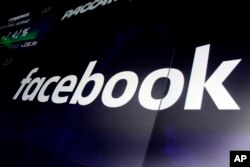 FILE - The logo for Facebook appears on screens at the Nasdaq MarketSite, in New York's Times Square, March 29, 2018.