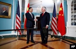 Secretary of State Rex Tillerson shakes hands with Chinese State Councilor Yang Jiechi during a photo opportunity at the State Department in Washington, Feb. 8, 2018.